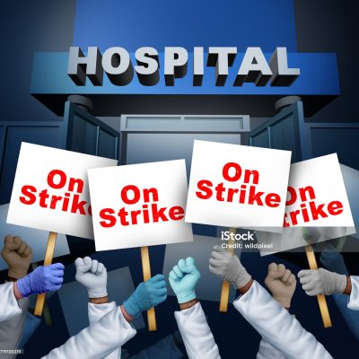 Hospital workers on strike ans Health Care Worker picketing as medical staff with pickets striking for better benefits and working conditions for Nurses doctors and clinic employees.