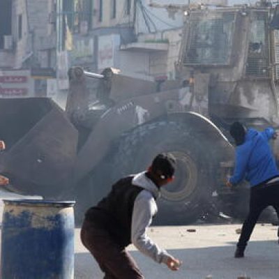 epa10431221 Palestinians throw stones amid clashes with Israeli troops during a raid in Jenin, West Bank, 26 January 2023. At least nine Palestinians were killed, including an elderly woman, during clashes in Jenin on 26 January, according to the Palestinian Health Ministry. Israeli security forces said they conducted a 'counterterrorism operation' in the center of Jenin.  EPA/ALAA BADARNEH