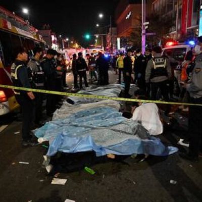 TOPSHOT - The bodies of victims, believed to have suffered from cardiac arrest, are covered with sheets in the popular nightlife district of Itaewon in Seoul on October 30, 2022. - Dozens of people suffered from cardiac arrest in the South Korean capital Seoul on October 29, after thousands of people crowded into narrow streets in the city's Itaewon neighbourhood to celebrate Halloween, local officials said. (Photo by Jung Yeon-je / AFP)